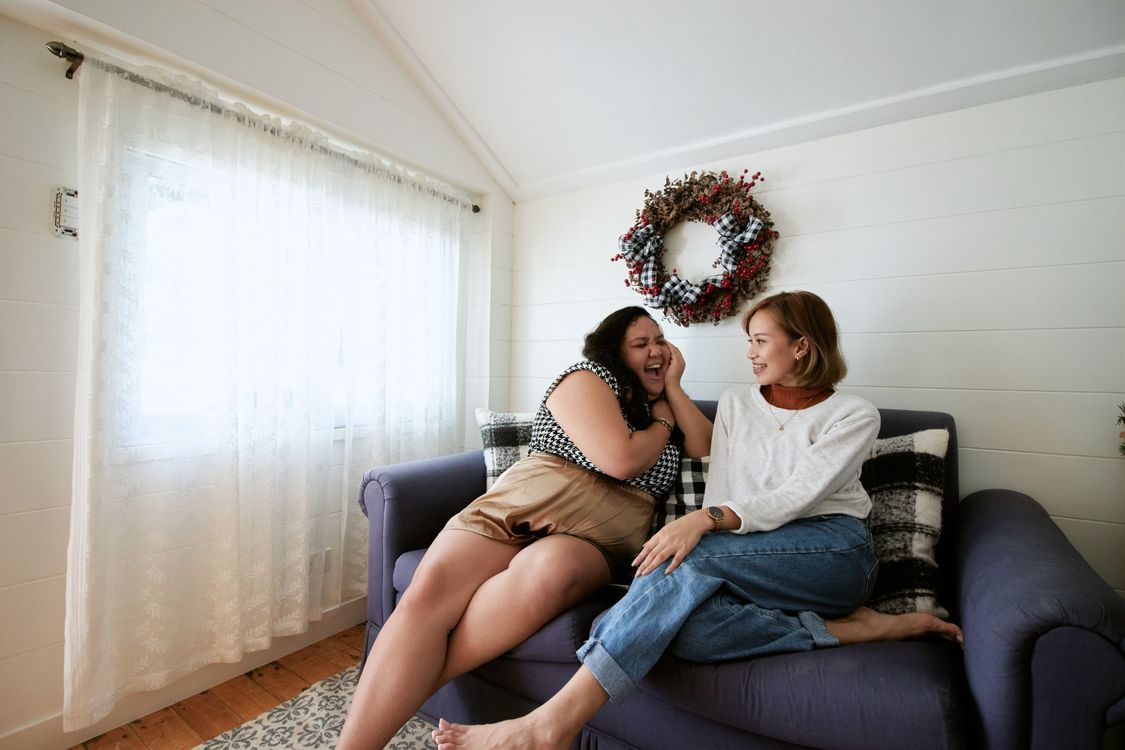 Two women sharing a relaxed conversation at home.